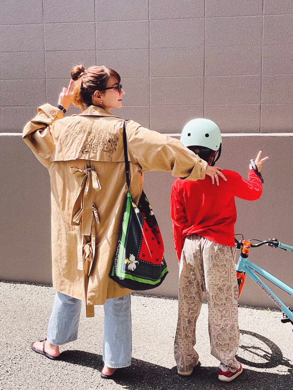 ブラック系のサンダル、ブルー系のデニムパンツ、レッド系のトートバッグを着用したレディースの春コーディネートの4枚目の写真