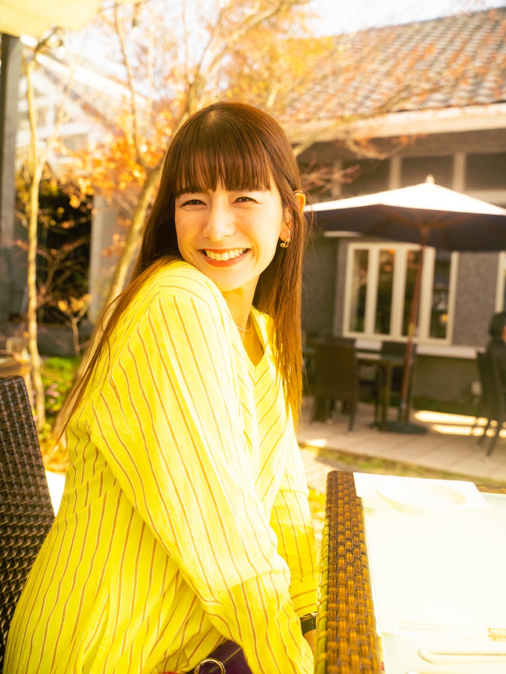 グリーン系のワンピース、ベージュ系のブーツ、ブルー系のバッグを着用したレディースの春コーディネートの2枚目の写真