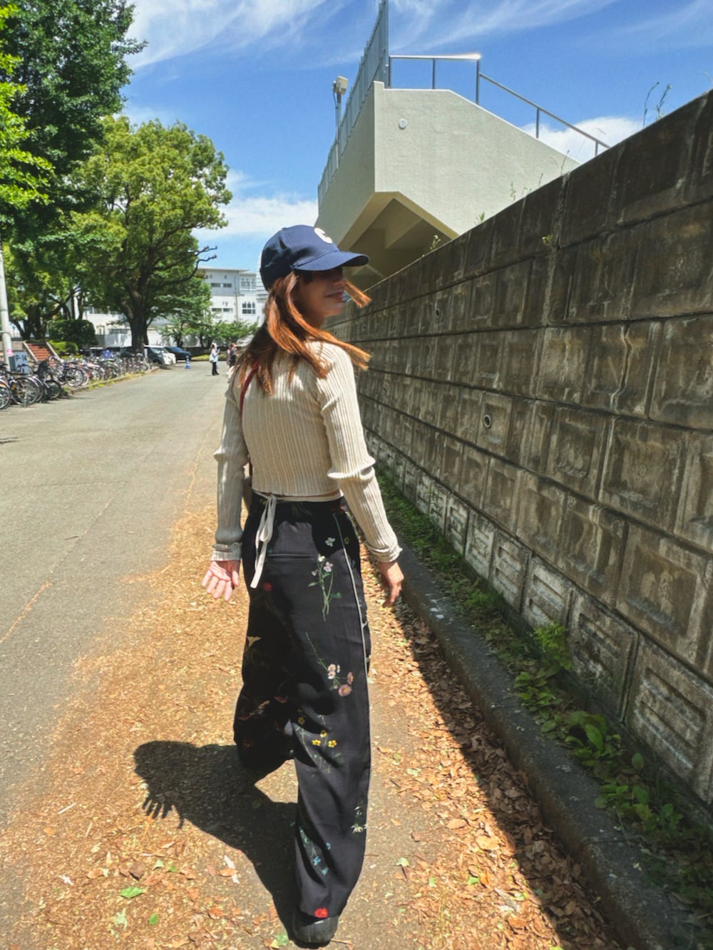 ブラック系のその他パンツ、ベージュ系のトップス、ブラック系のスニーカーを着用したレディースの春コーディネートの2枚目の写真