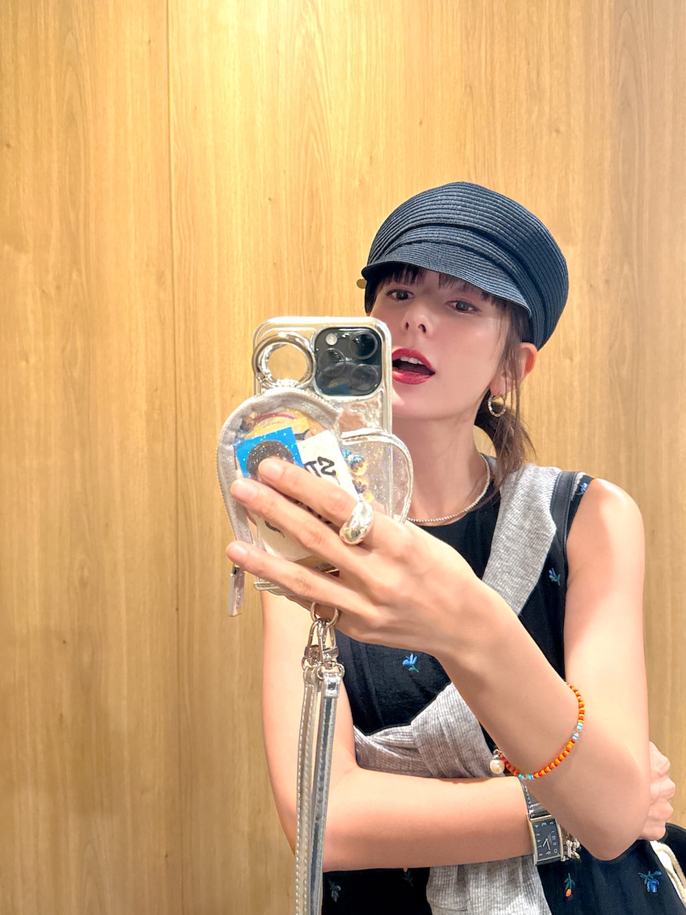 ブラック系のワンピース、ブラック系のサンダル、グレー系のカーディガン/ボレロを着用したレディースの夏コーディネートの2枚目の写真