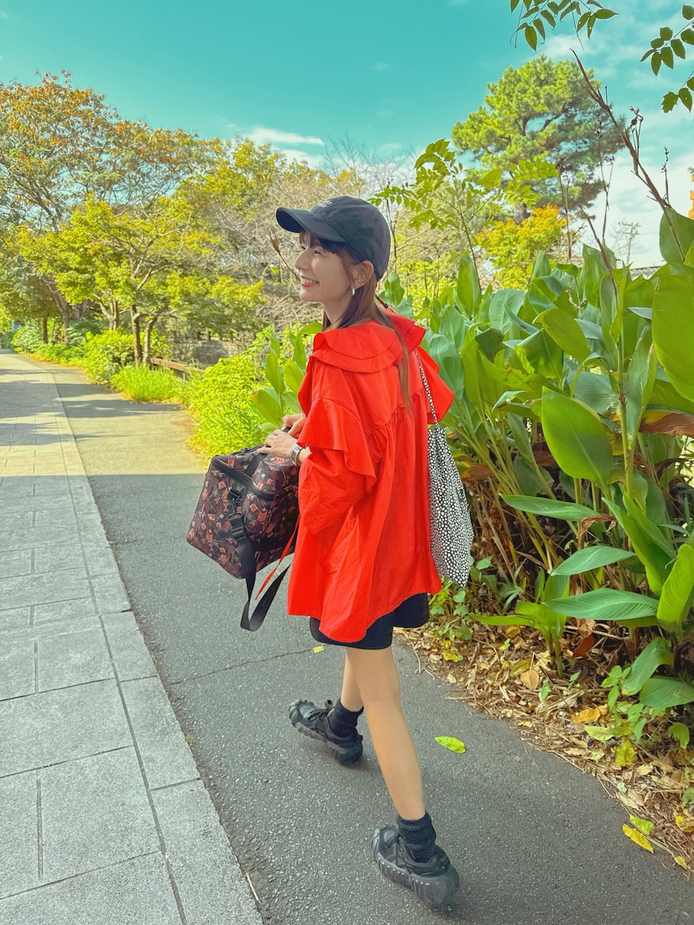 レッド系のシャツ/ブラウス、ブラック系のデニムパンツ、ブラック系のスニーカーを着用したレディースの秋コーディネートの2枚目の写真