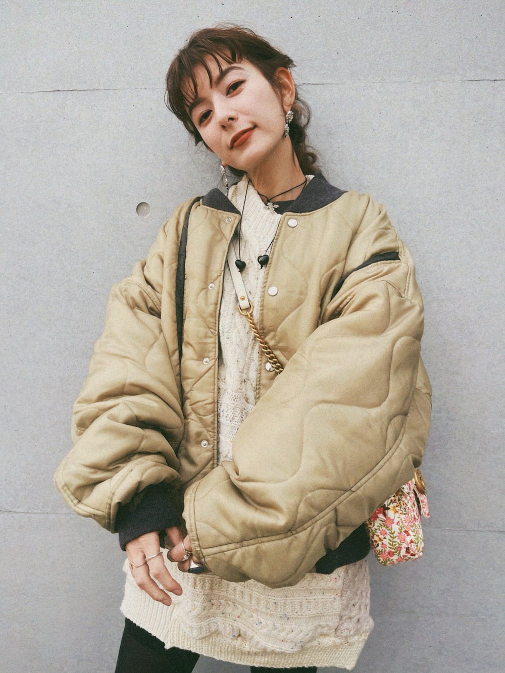 グリーン系のスタジャン、ベージュ系のニット/セーター、ブラック系のその他パンツを着用したレディースの冬コーディネートの4枚目の写真