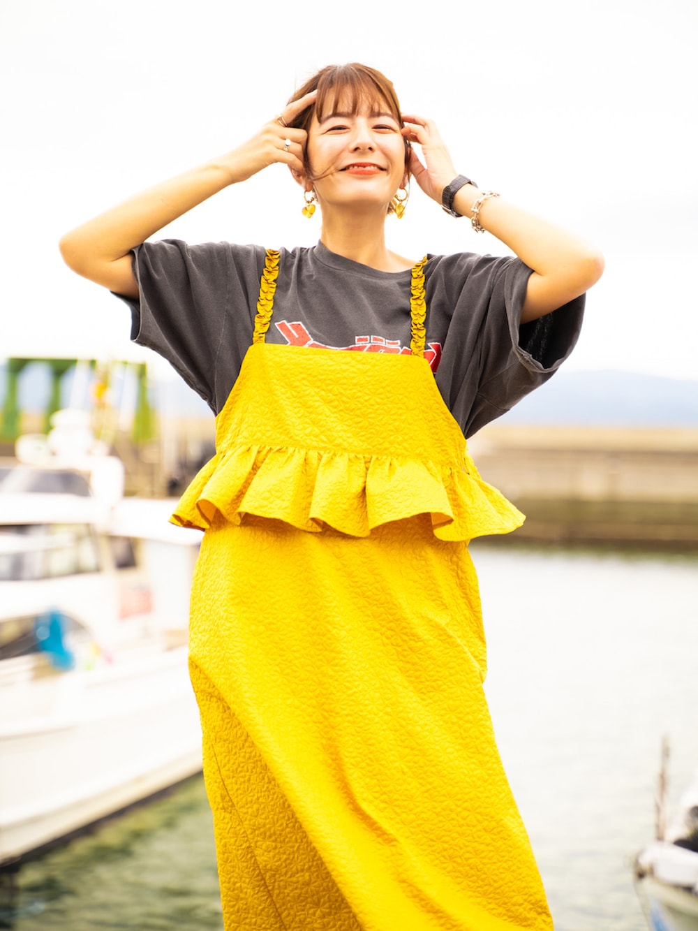 イエロー系のワンピース、その他のスニーカー、ブラック系のTシャツ/カットソーを着用したレディースの秋コーディネートの2枚目の写真