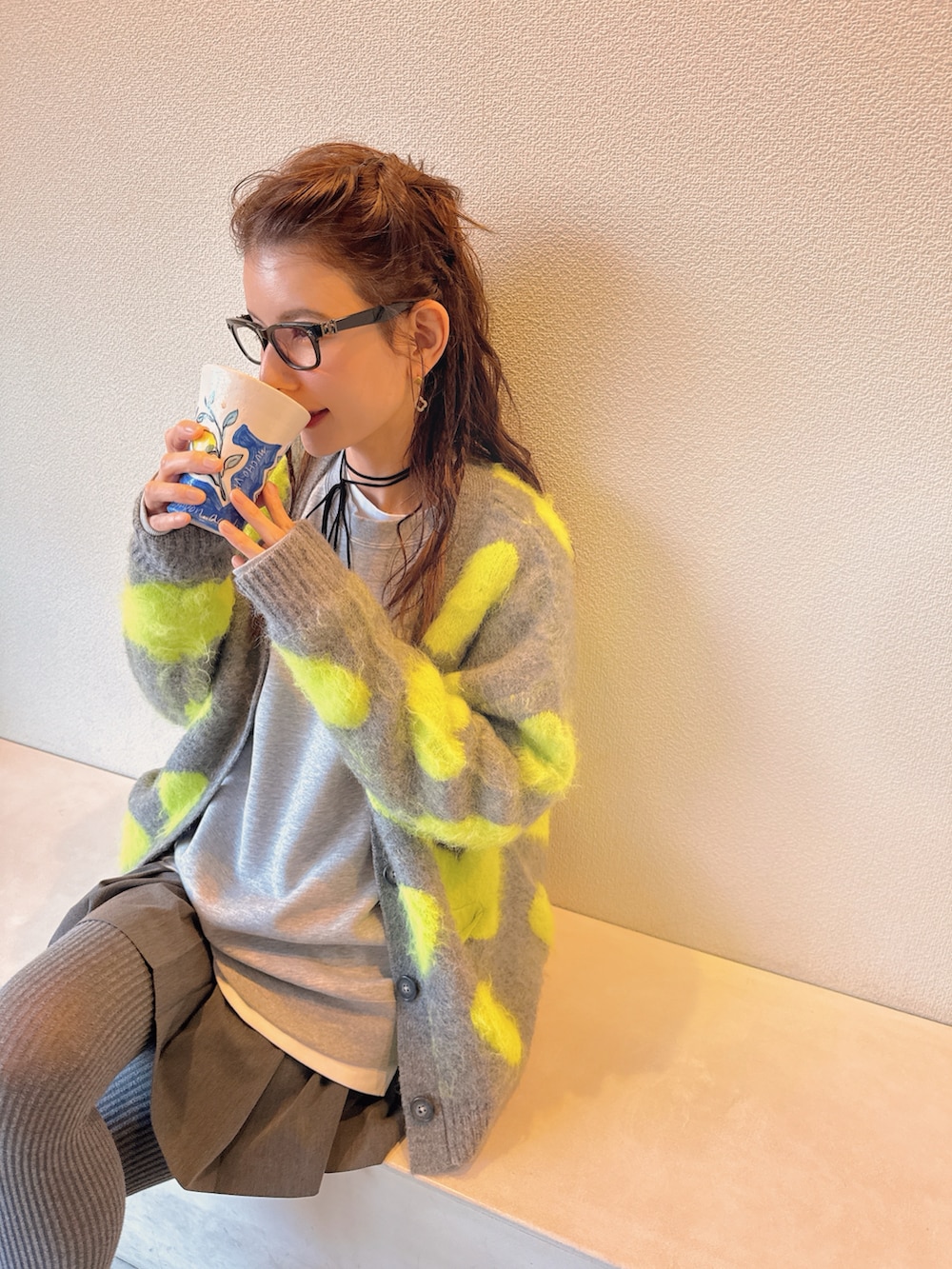 ベージュ系のスニーカー、グレー系のスウェット、グレー系のスカートを着用したレディースの冬コーディネートの2枚目の写真