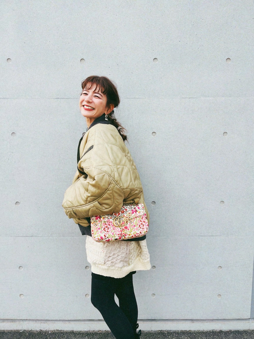 グリーン系のスタジャン、ベージュ系のニット/セーター、ブラック系のその他パンツを着用したレディースの冬コーディネートの3枚目の写真