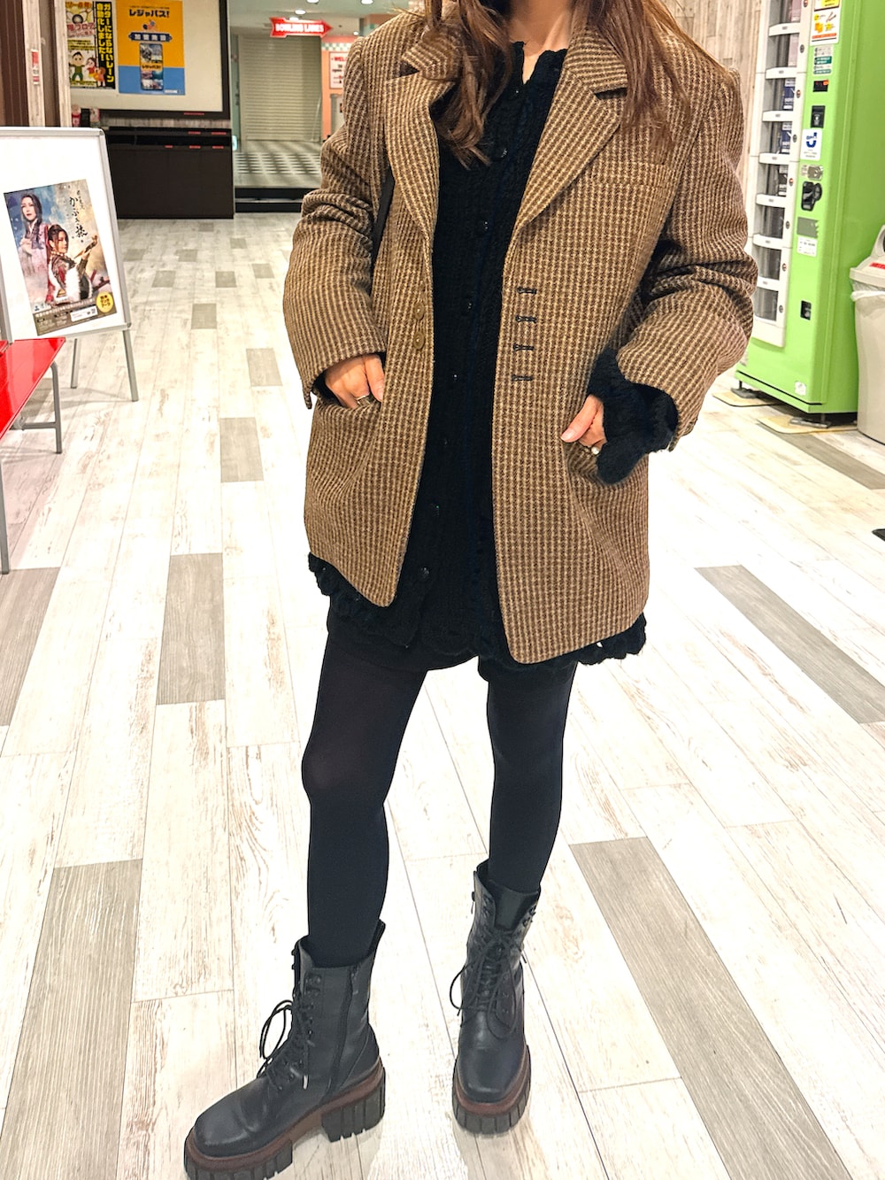 ベージュ系のカーゴパンツ、グリーン系のスウェット、ブラック系のブルゾンを着用したレディースの冬コーディネートの2枚目の写真