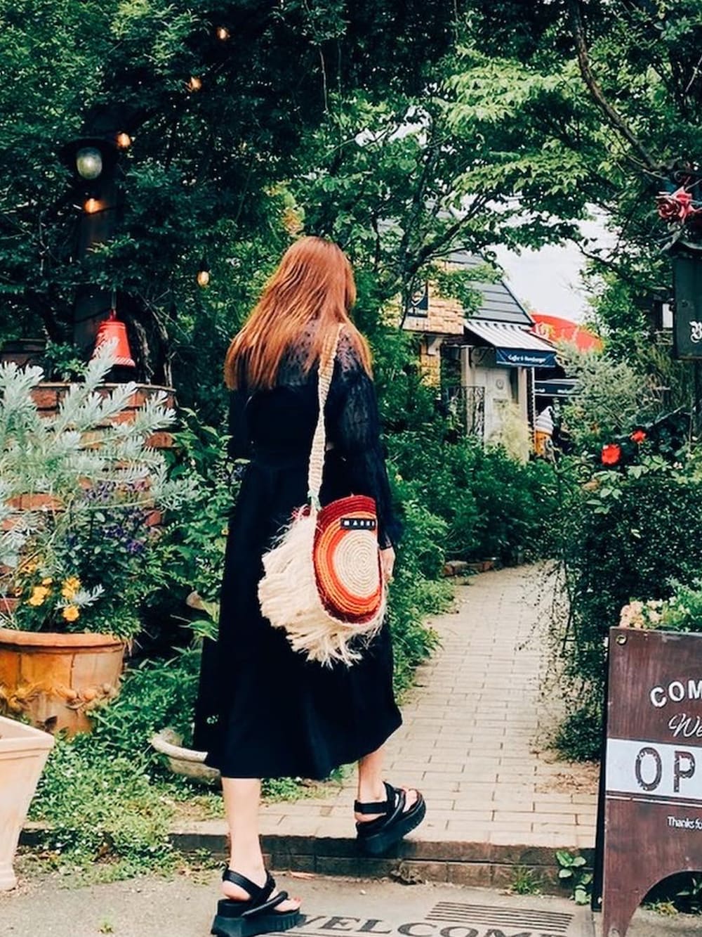 ブラック系のサンダル、その他のバッグ、ブラック系のキャップを着用したレディースの夏コーディネートの2枚目の写真