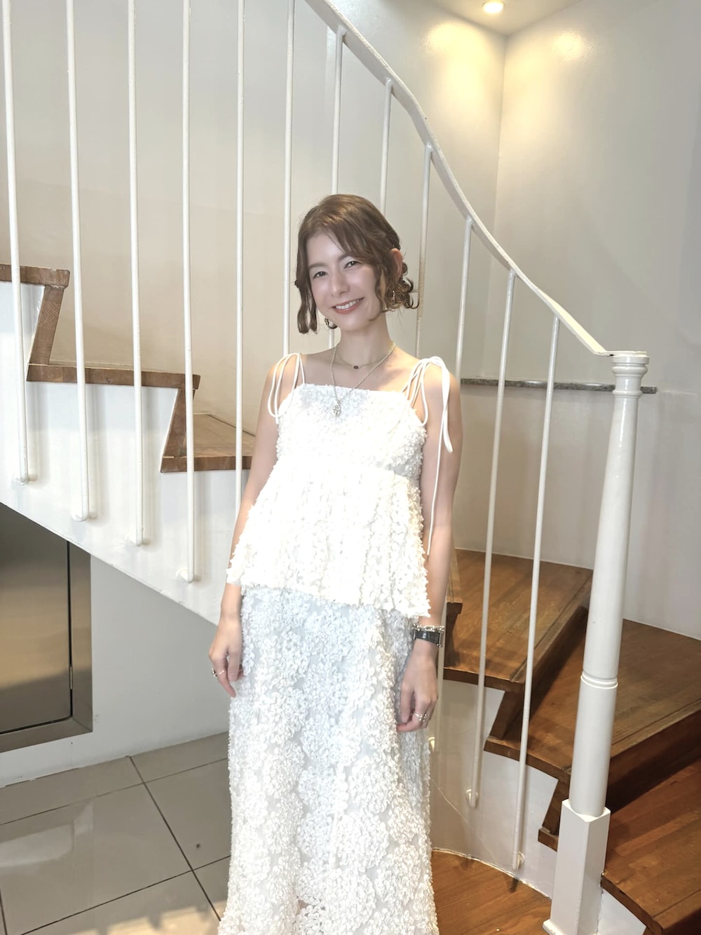 ホワイト系のワンピース、ベージュ系のトレンチコート、シルバー系のローファーを着用したレディースの夏コーディネートの2枚目の写真