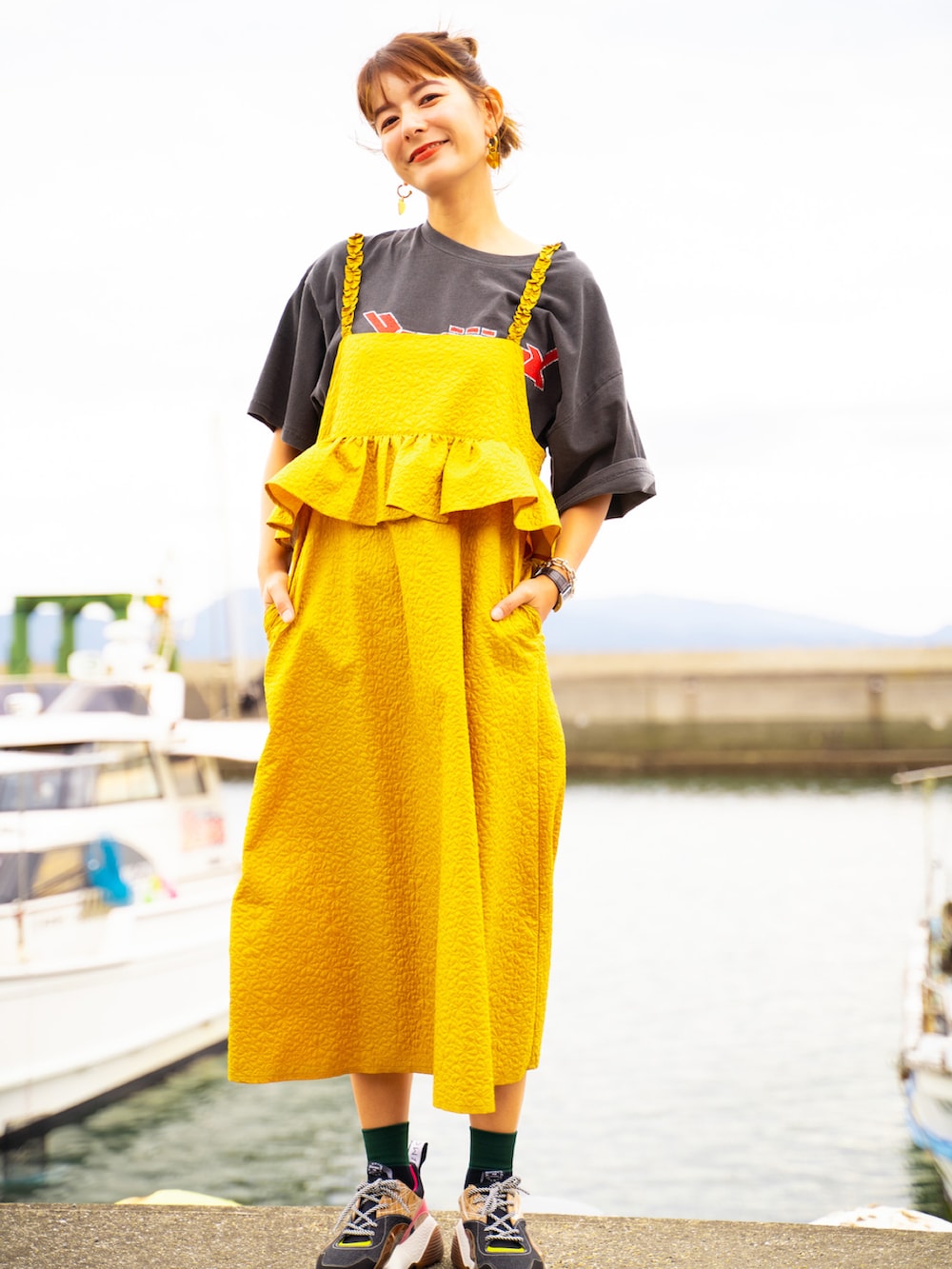 イエロー系のワンピース、その他のスニーカー、ブラック系のTシャツ/カットソーを着用したレディースの秋コーディネートの3枚目の写真