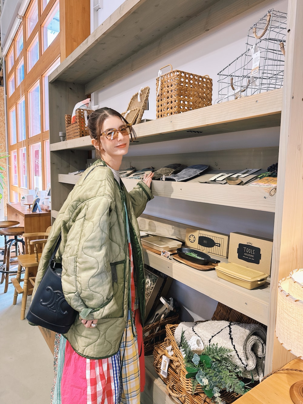 ブラック系のスニーカー、ホワイト系のワンピース、グレー系のニット/セーターを着用したレディースの春コーディネートの2枚目の写真