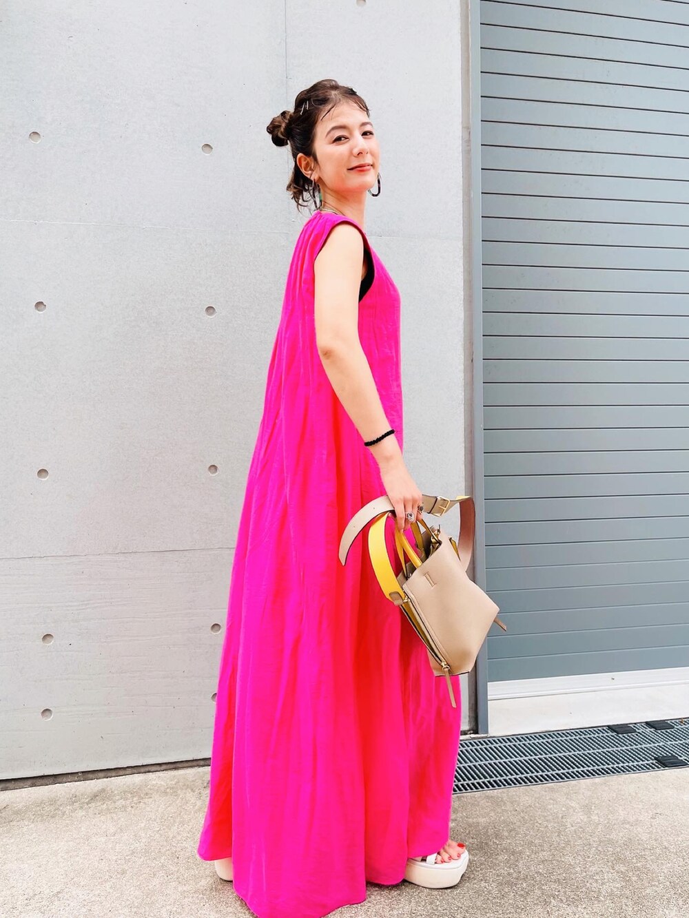 ホワイト系のサンダル、ベージュ系のバッグ、ピンク系のオールインワン・サロペットを着用したレディースの夏コーディネートの2枚目の写真