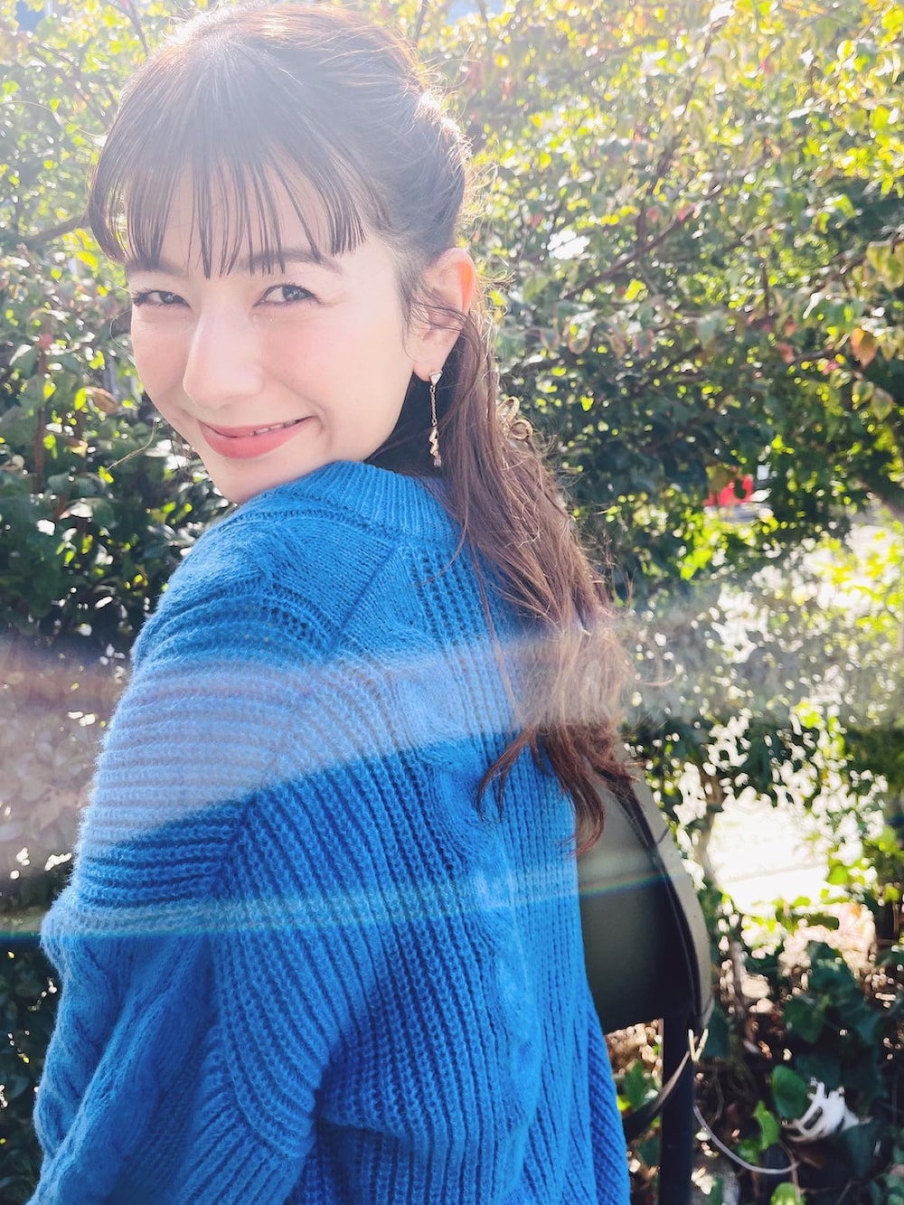 グリーン系のバッグ、ホワイト系のブーツを着用したレディースの秋コーディネートの2枚目の写真
