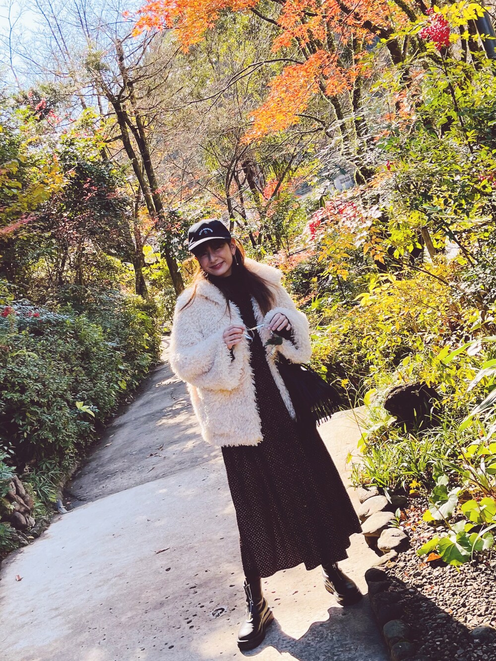 ブラック系のワンピース、ピンク系のバッグ、ブラック系のシューズを着用したレディースの冬コーディネートの2枚目の写真