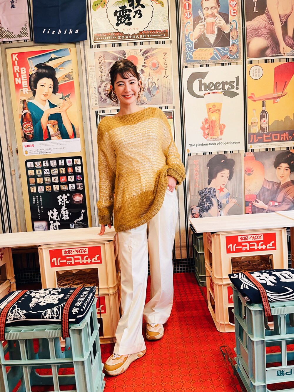 ホワイト系のスラックス、グリーン系のニット/セーター、ベージュ系のスニーカーを着用したレディースの春コーディネートの2枚目の写真