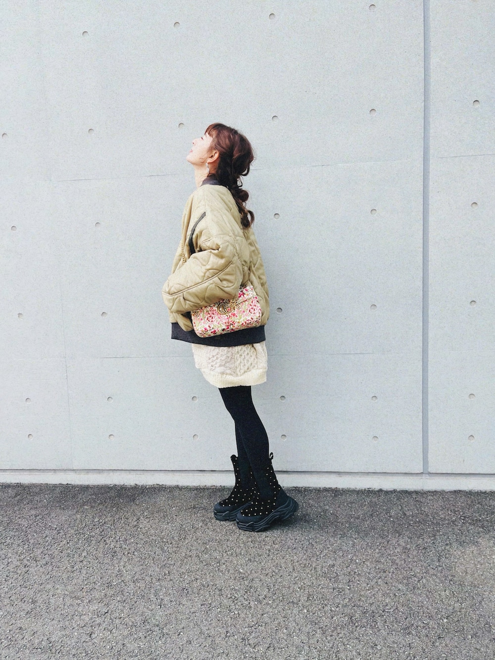 グリーン系のスタジャン、ベージュ系のニット/セーター、ブラック系のその他パンツを着用したレディースの冬コーディネートの2枚目の写真