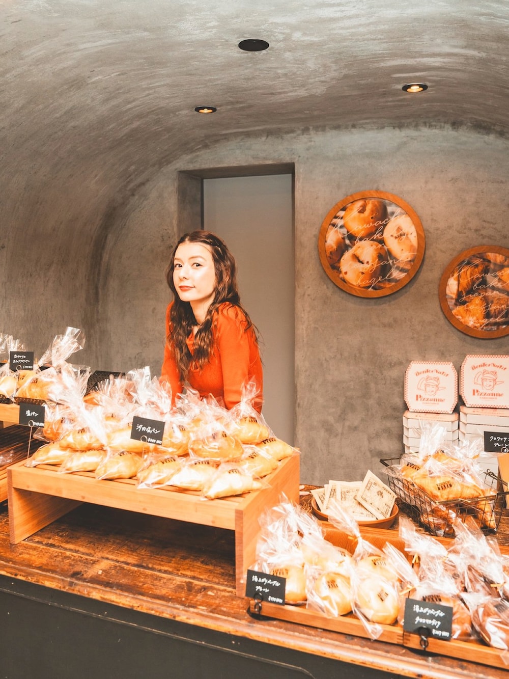 オレンジ系のTシャツ/カットソー、ブルー系のデニムパンツを着用したレディースの春コーディネートの3枚目の写真