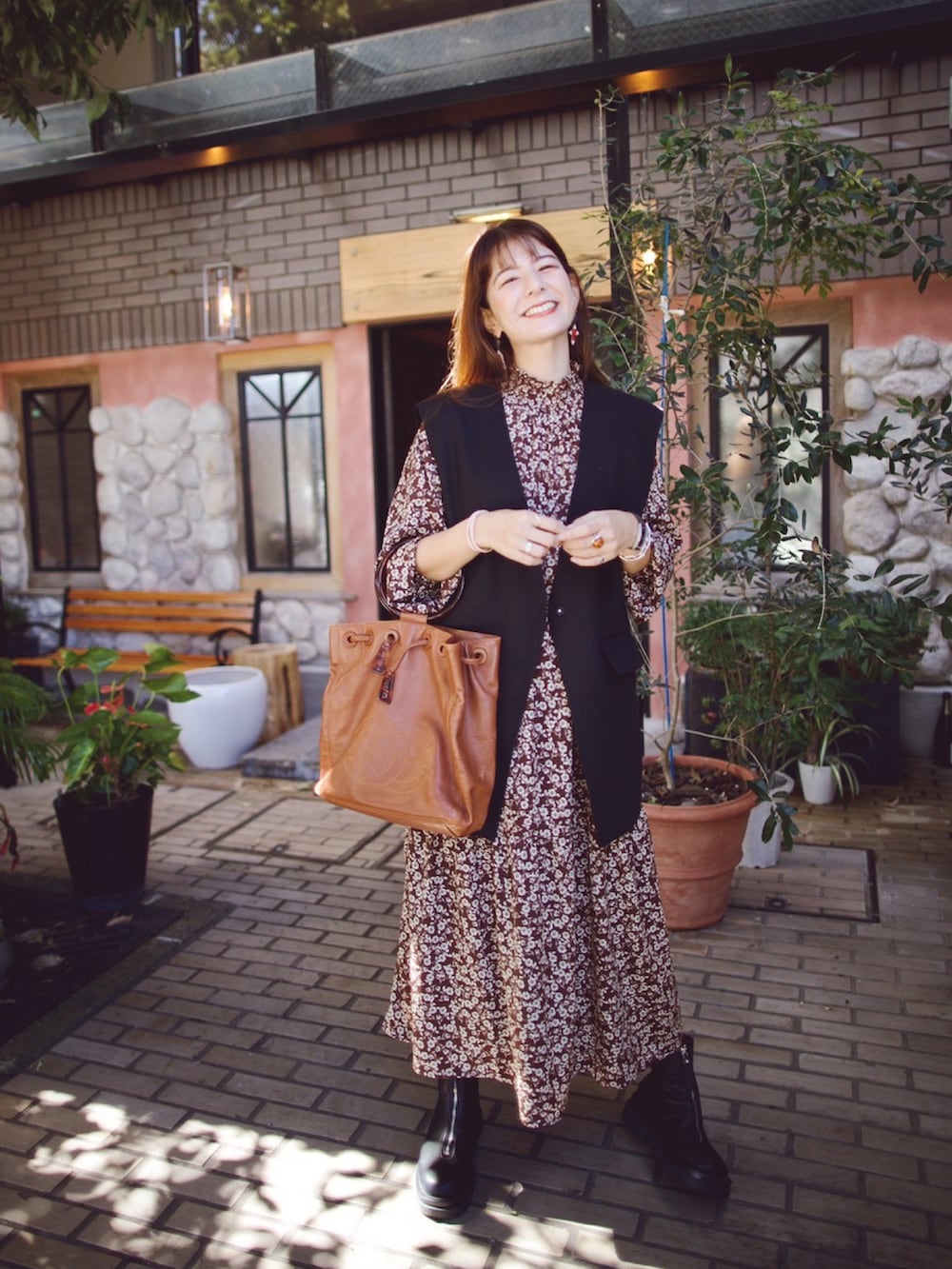 ブラウン系のワンピース、ブラック系のシューズ、ブラウン系のトートバッグを着用したレディースの秋コーディネートの2枚目の写真
