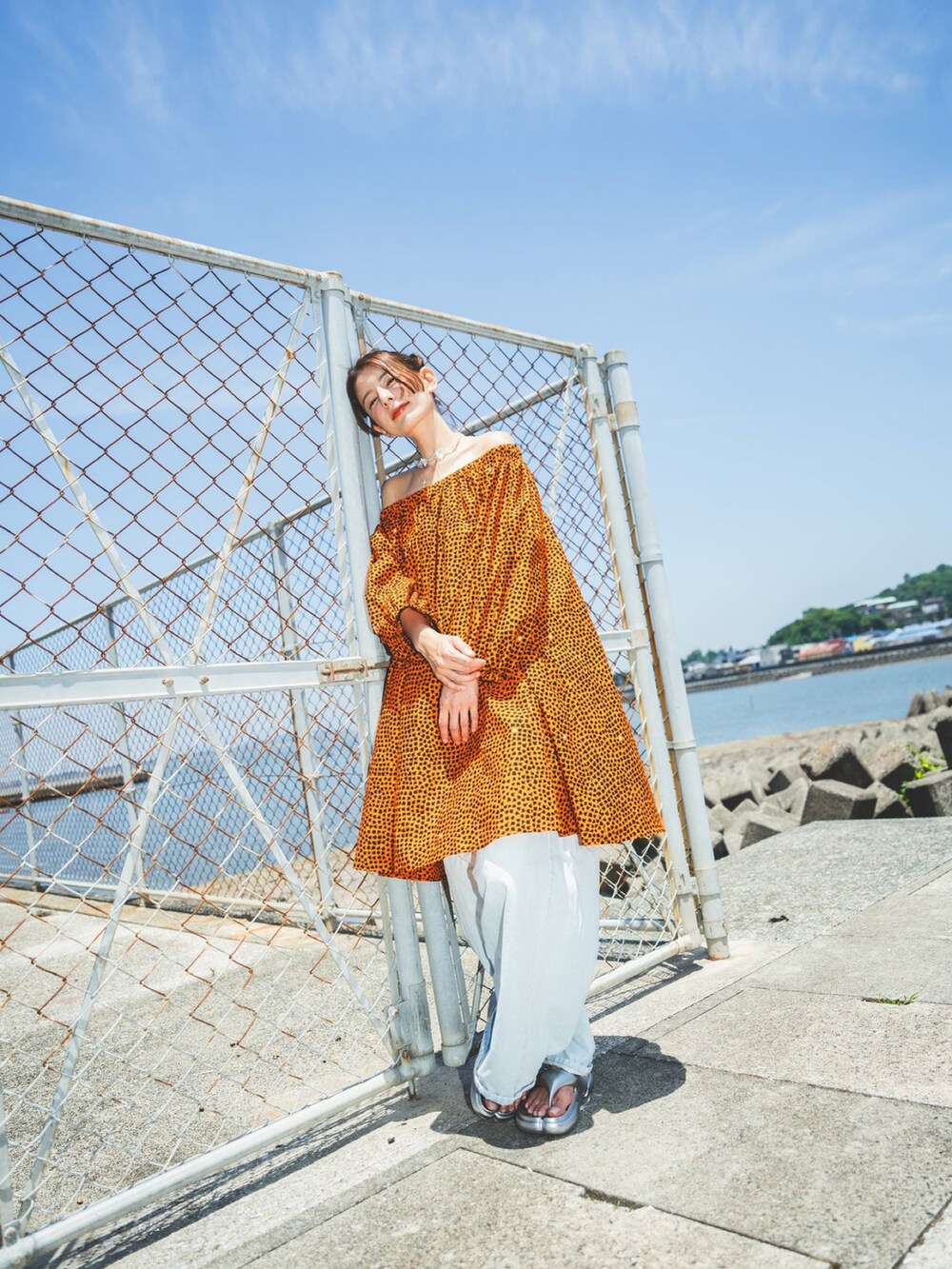 ブルー系のデニムパンツ、オレンジ系のワンピース/ドレスを着用したレディースの夏コーディネートの3枚目の写真