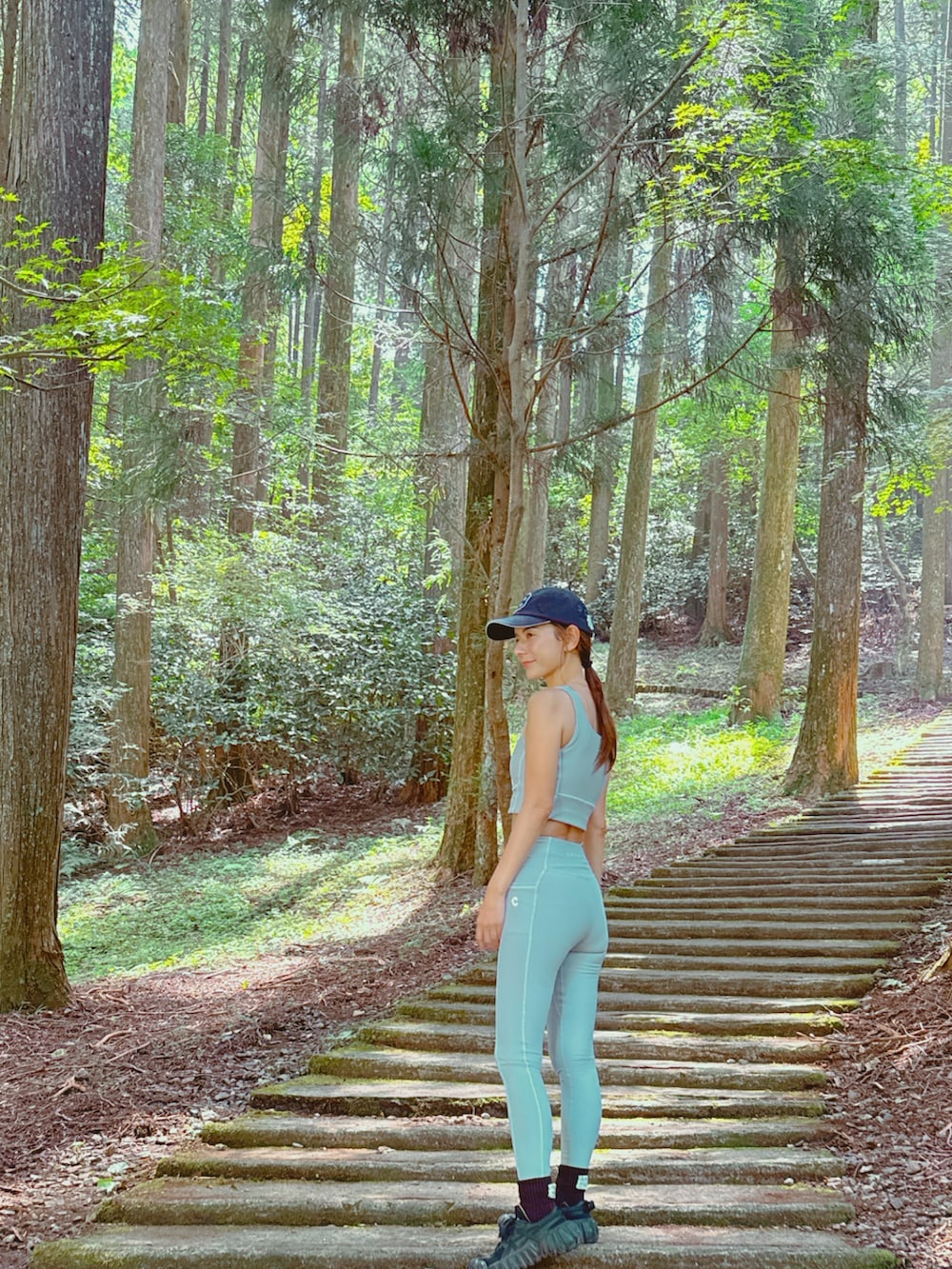 グレー系のトップス、ブルー系のキャップを着用したレディースの秋コーディネートの2枚目の写真