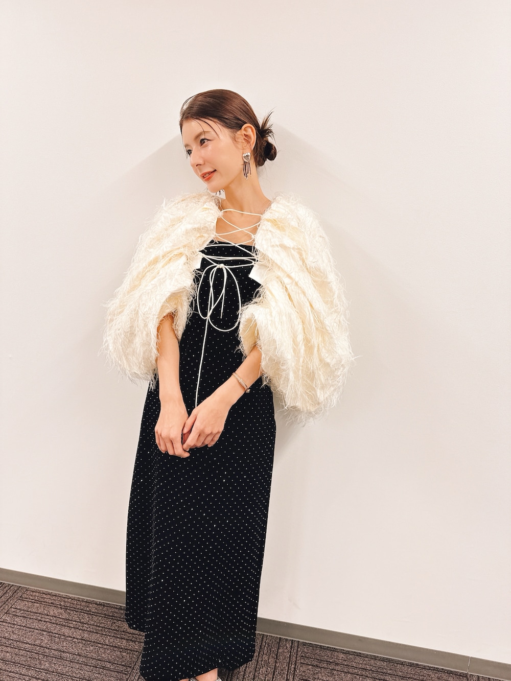 ブラック系のドレス、ホワイト系のトップス、シルバー系のサンダルを着用したレディースの春コーディネートの2枚目の写真