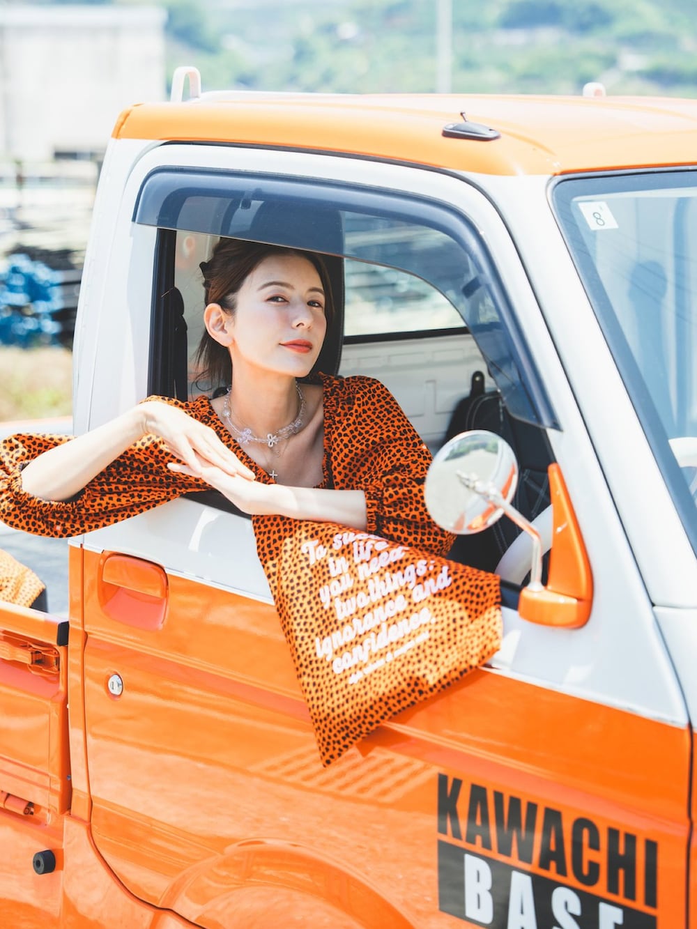ブルー系のデニムパンツ、オレンジ系のワンピース/ドレスを着用したレディースの夏コーディネートの2枚目の写真