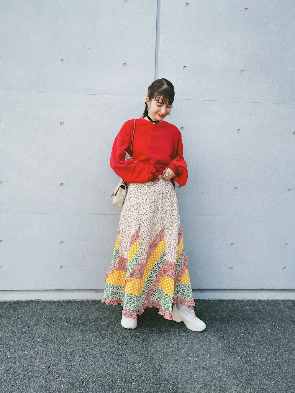 ベージュ系のスカート、ホワイト系のスニーカー、レッド系のトップスを着用したレディースの秋コーディネートの3枚目の写真