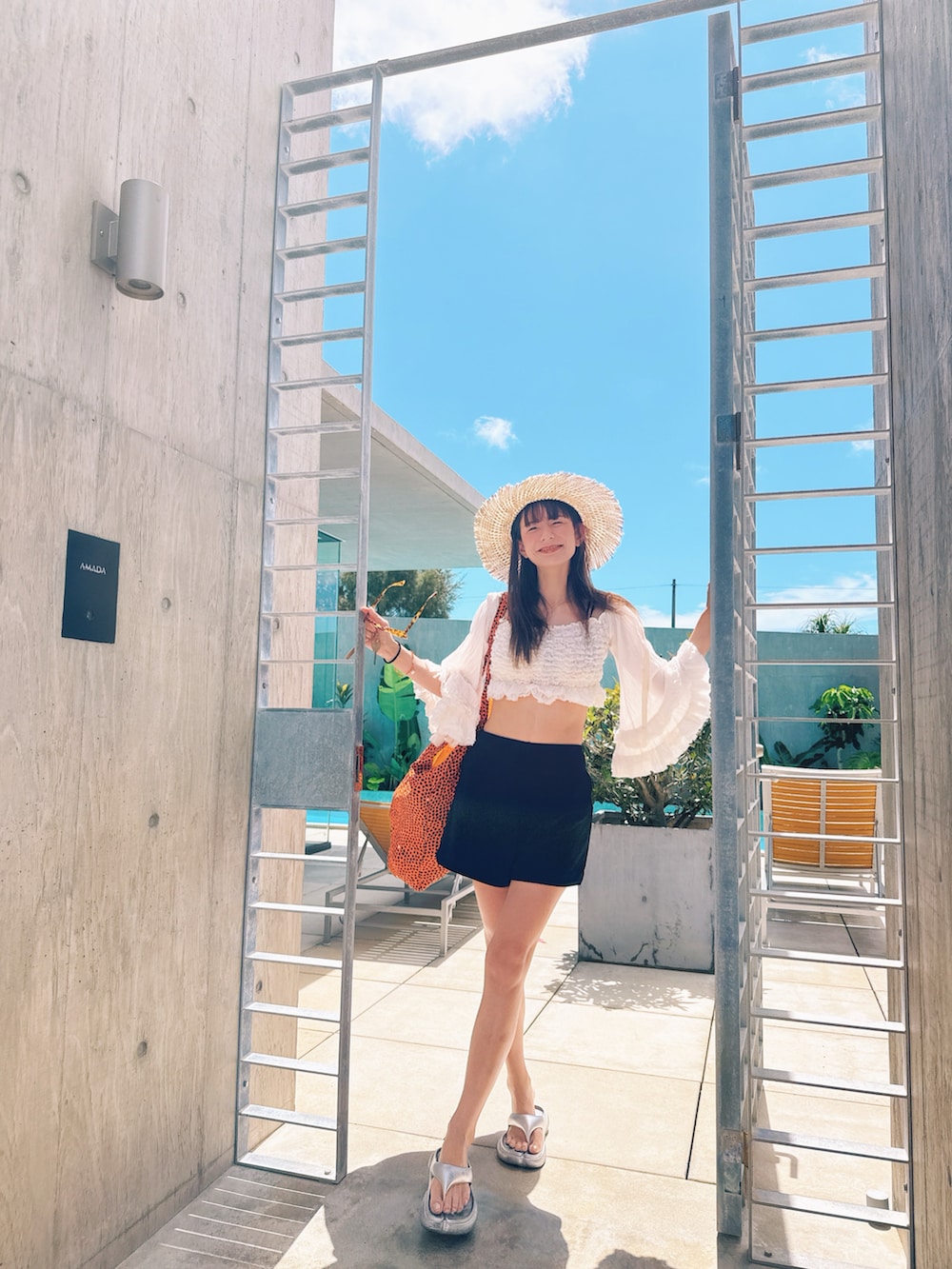 シルバー系のサンダル、ブルー系のトートバッグ、ブラック系の水着を着用したレディースの夏コーディネートの4枚目の写真