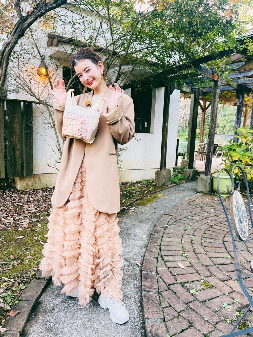 ブラック系のスカート、ベージュ系のハンドバッグ、ベージュ系のノーカラージャケットを着用したレディースの秋コーディネートの5枚目の写真