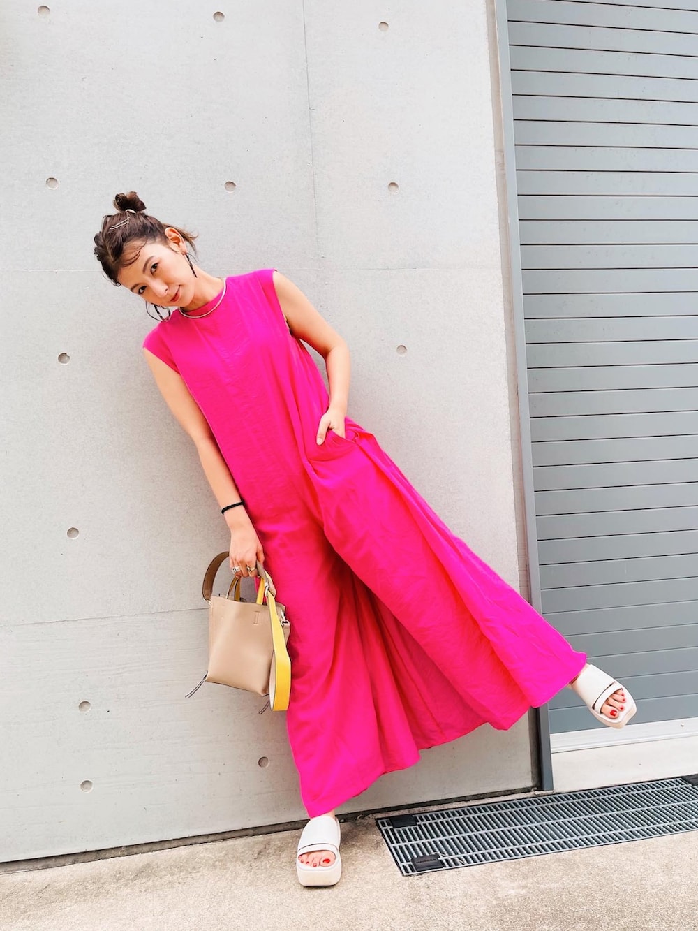 ホワイト系のサンダル、ベージュ系のバッグ、ピンク系のオールインワン・サロペットを着用したレディースの夏コーディネートの3枚目の写真