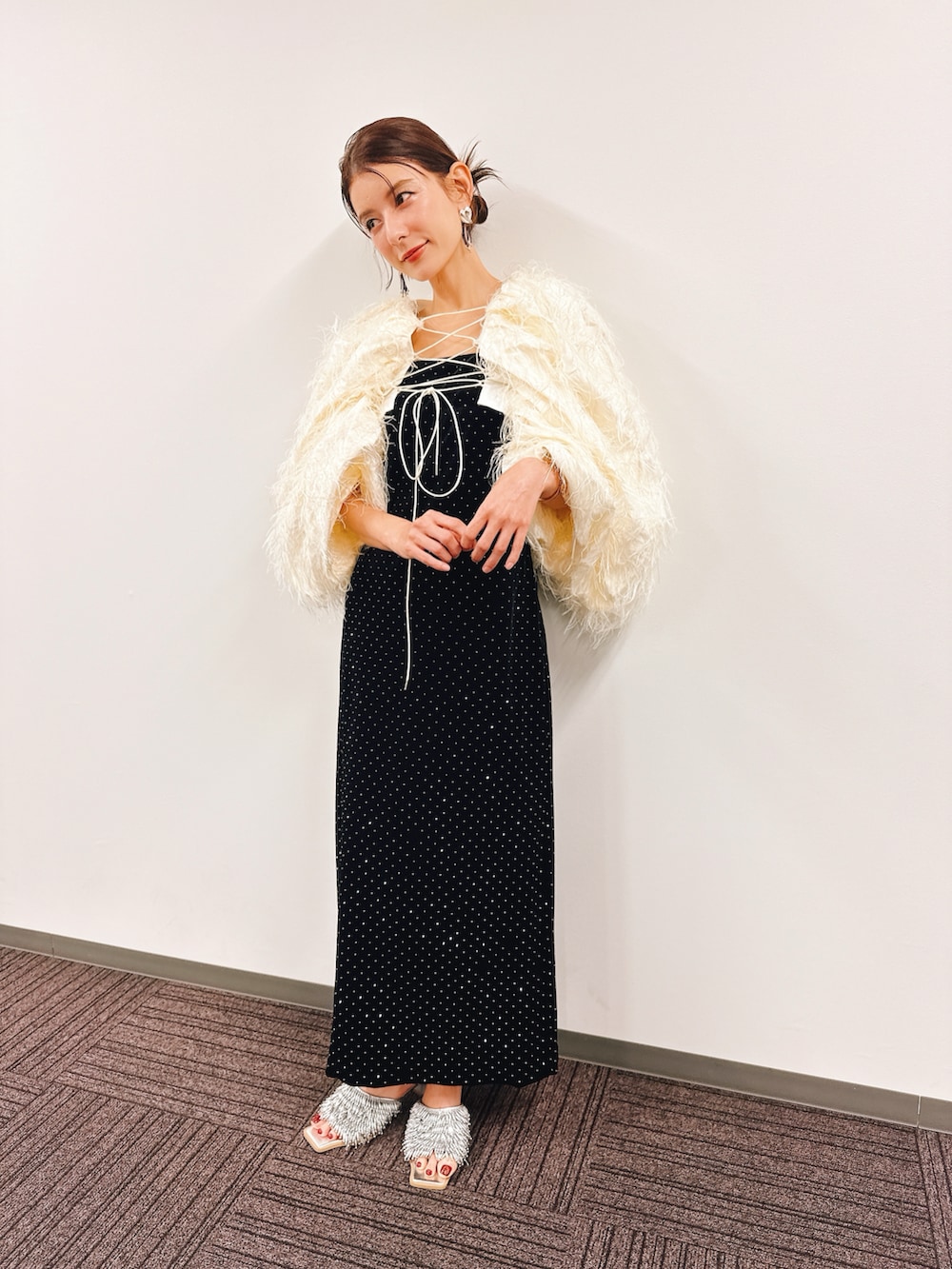 ブラック系のドレス、ホワイト系のトップス、シルバー系のサンダルを着用したレディースの春コーディネートの3枚目の写真