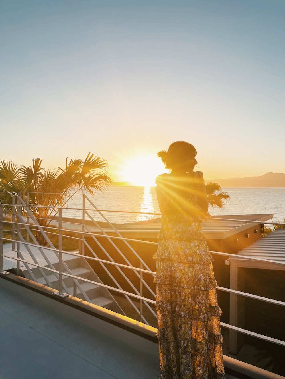 イエロー系のワンピース/ドレス、ブラック系のチューブトップ、ホワイト系のネックレスを着用したレディースの夏コーディネートの2枚目の写真