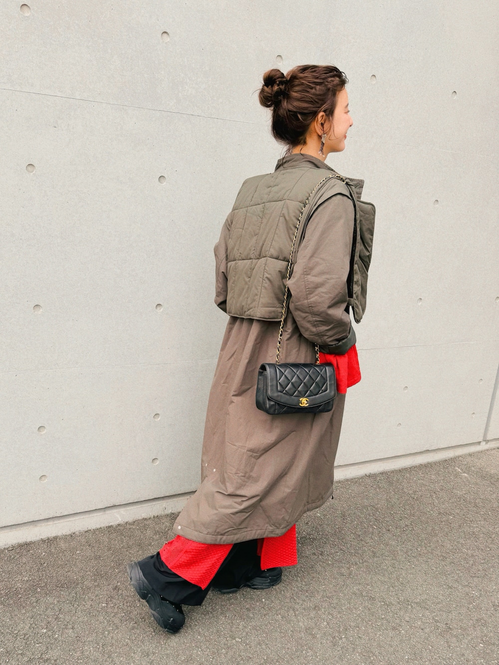 レッド系のワンピース、ベージュ系のTシャツ/カットソー、グリーン系のモッズコートを着用したレディースの春コーディネートの3枚目の写真