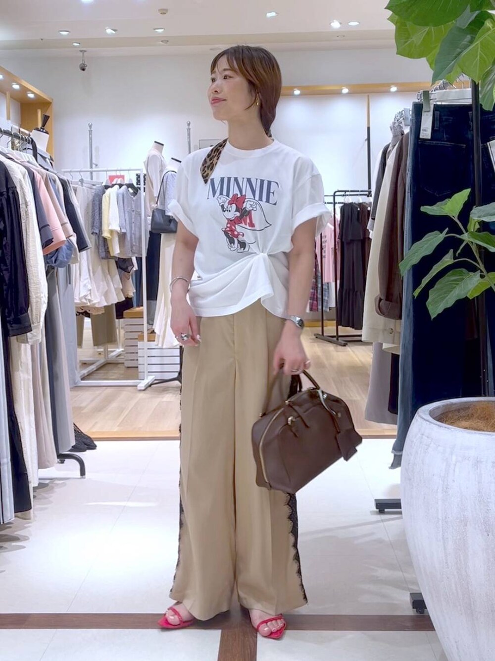 ベージュ系のスラックス、ホワイト系のTシャツ/カットソーを着用したレディースの夏コーディネートの5枚目の写真