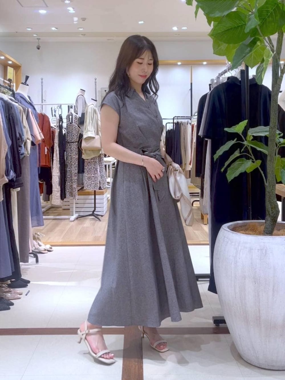 グレー系のワンピース、ベージュ系のサンダル、ベージュ系のショルダーバッグを着用したレディースの夏コーディネートの2枚目の写真