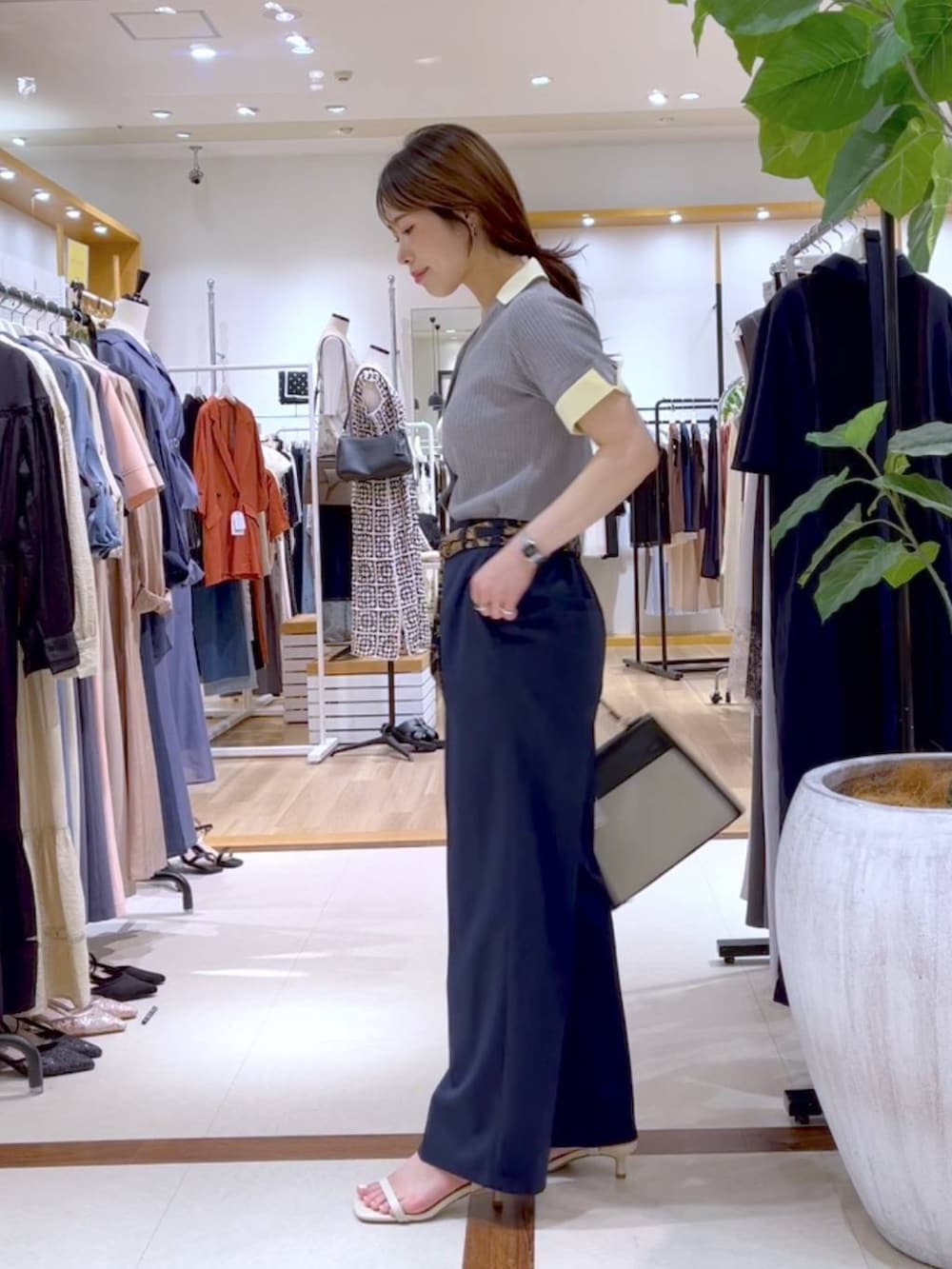ブルー系のスラックス、ブラック系のトートバッグ、ベージュ系のサンダルを着用したレディースの夏コーディネートの3枚目の写真