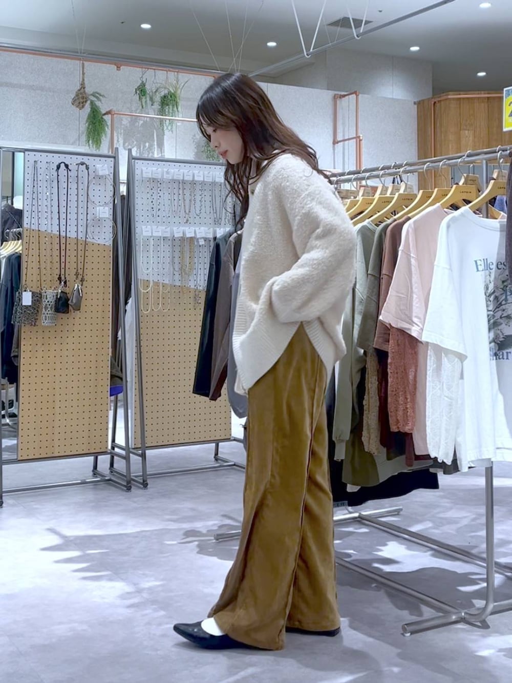 ブラック系のショルダーバッグ、イエロー系のその他パンツ、ホワイト系のTシャツ/カットソーを着用したレディースの秋コーディネートの2枚目の写真