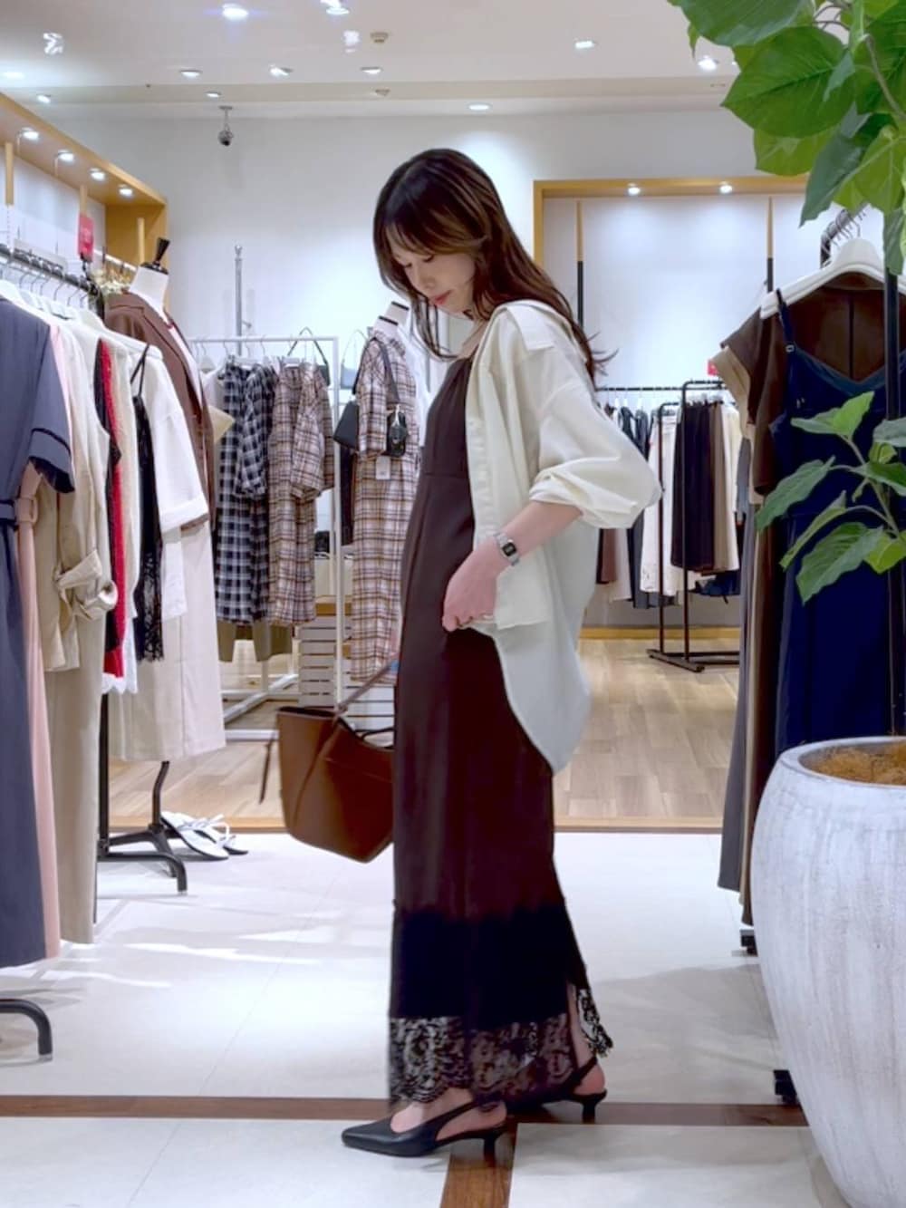 ブラウン系のワンピース、ホワイト系のシャツ/ブラウス、ブラック系のパンプスを着用したレディースの夏コーディネートの3枚目の写真