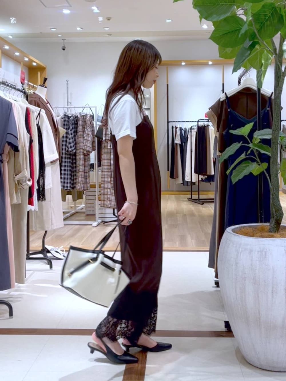 ブラウン系のワンピース、ブラック系のハンドバッグ、ブラック系のパンプスを着用したレディースの夏コーディネートの3枚目の写真