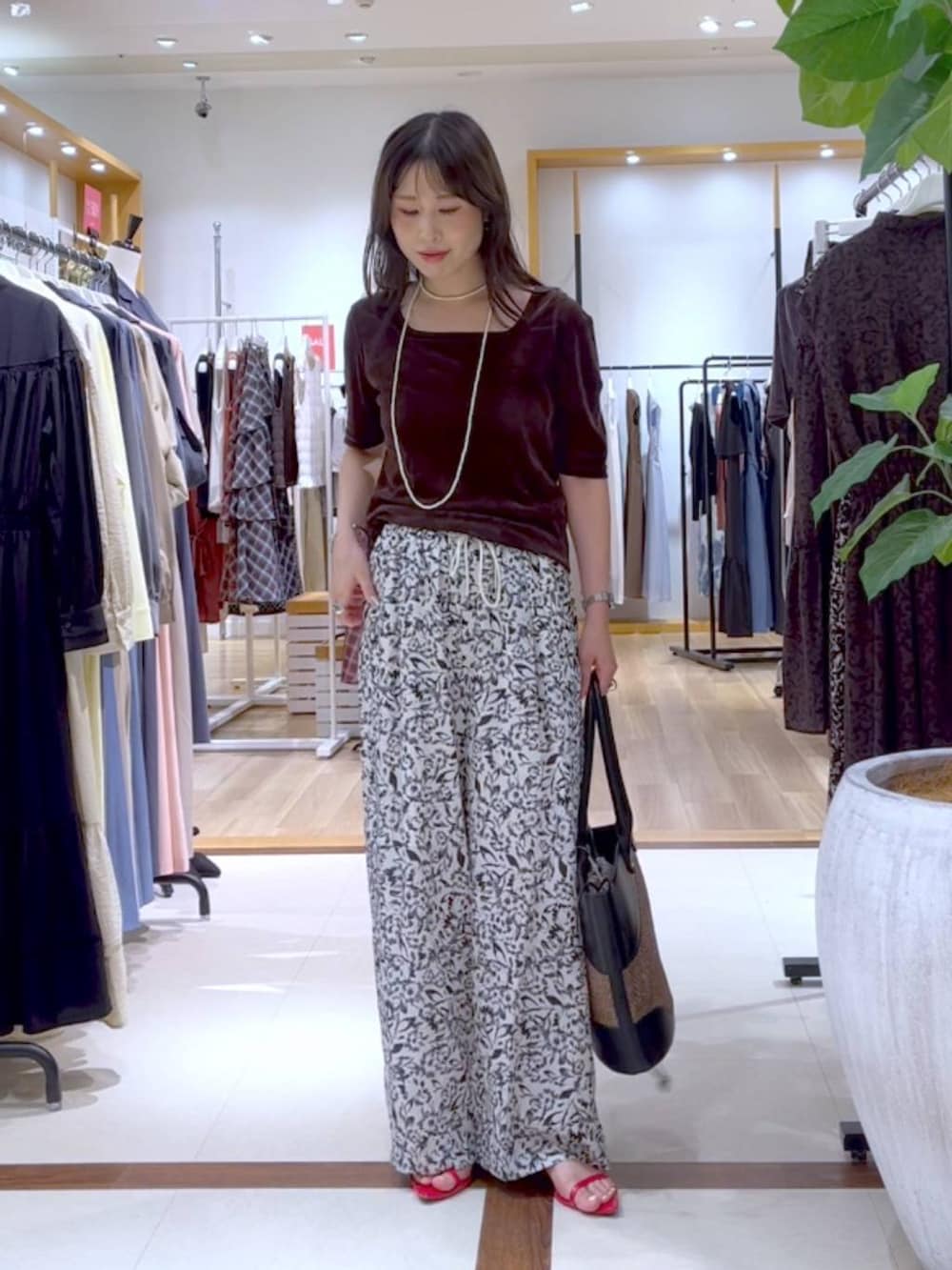 ホワイト系のスラックス、ブラウン系のTシャツ/カットソー、ブラウン系のTシャツ/カットソーを着用したレディースの夏コーディネートの2枚目の写真