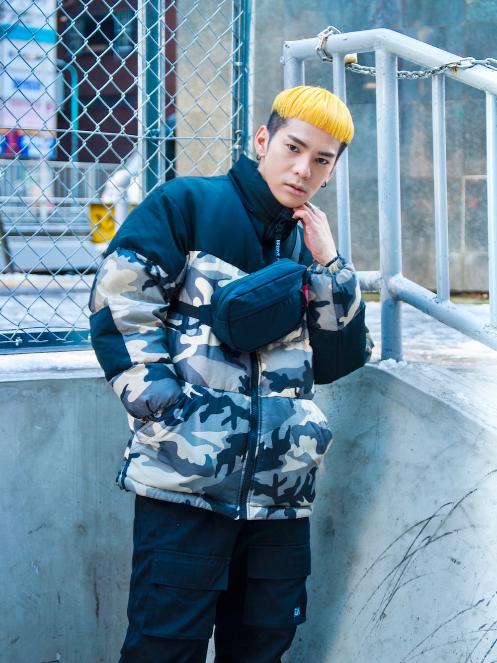 ブルー系のボディバッグ/ウエストポーチ、ブラック系のチノパンツ、ブラック系のダウンジャケット/コートを着用したメンズの冬コーディネートの2枚目の写真