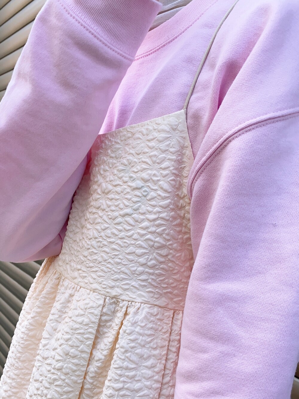 レッド系のシューズ、ブルー系のワンピース、その他のトートバッグを着用したレディースの冬コーディネートの2枚目の写真