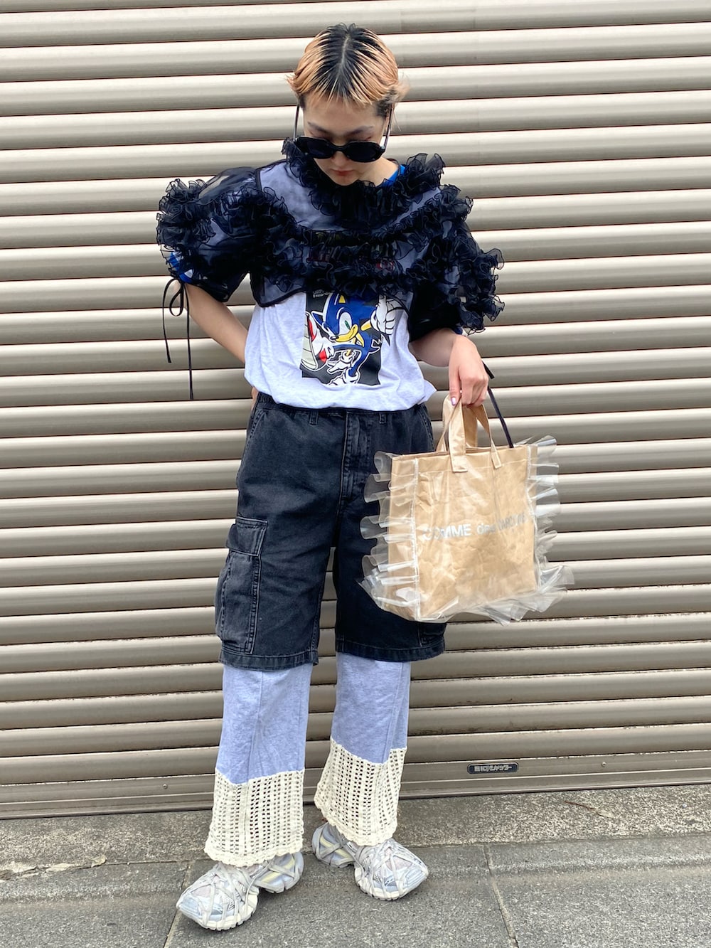 ブラック系のトップス、ベージュ系のトートバッグ、グレー系のパンツを着用したレディースの秋コーディネートの2枚目の写真