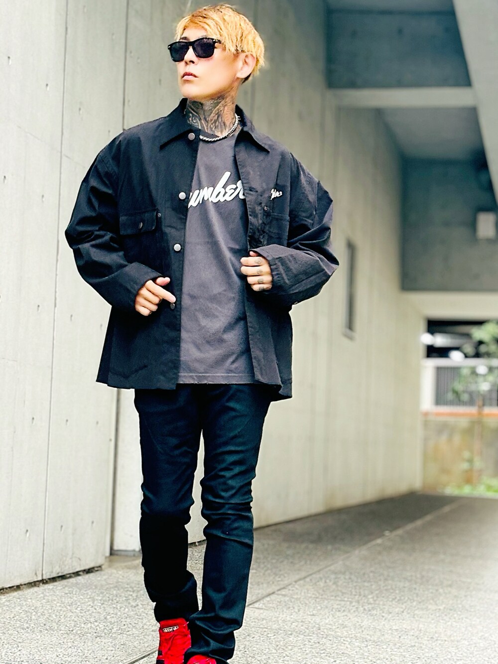 ブラック系のデニムパンツ、ブラック系のカバーオール、グレー系のTシャツ/カットソーを着用したメンズの秋コーディネートの4枚目の写真