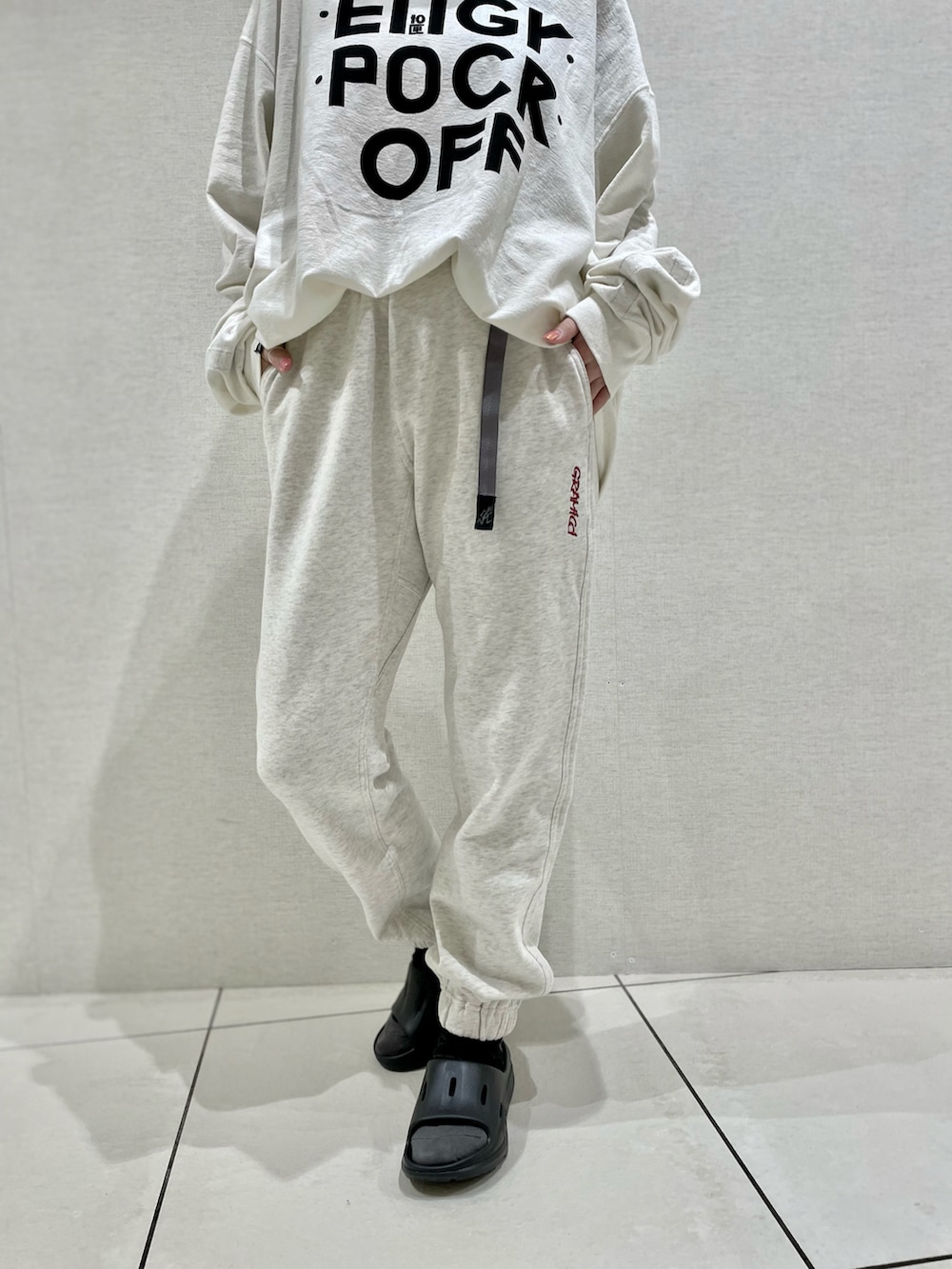 グレー系のスウェットパンツ、ホワイト系のTシャツ/カットソー、ブラック系のサンダルを着用したレディースの春コーディネートの3枚目の写真