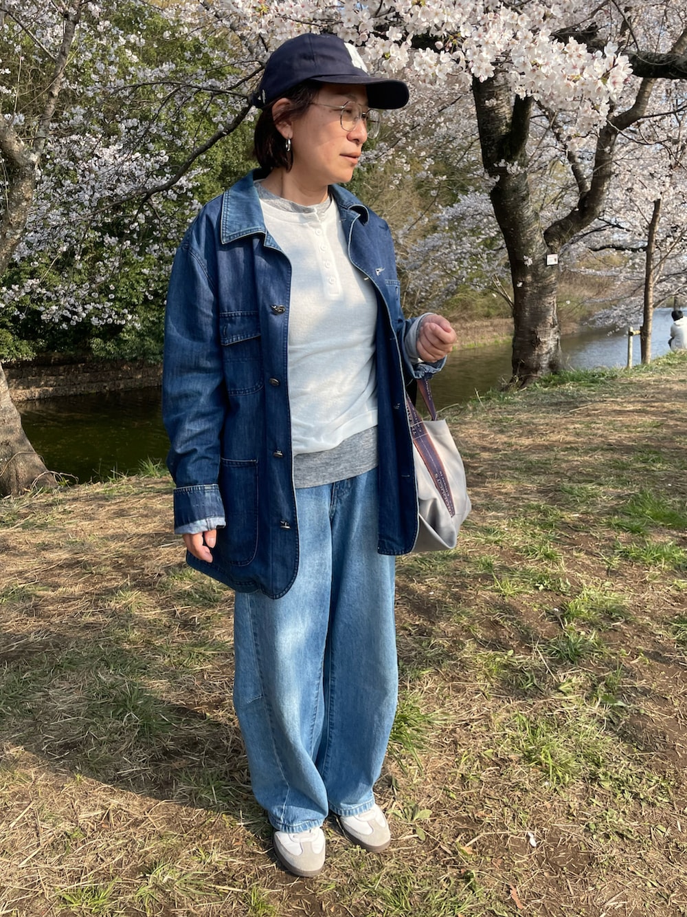 ホワイト系のTシャツ/カットソー、ブルー系のデニムパンツ、ホワイト系のスニーカーを着用したレディースの春コーディネートの2枚目の写真