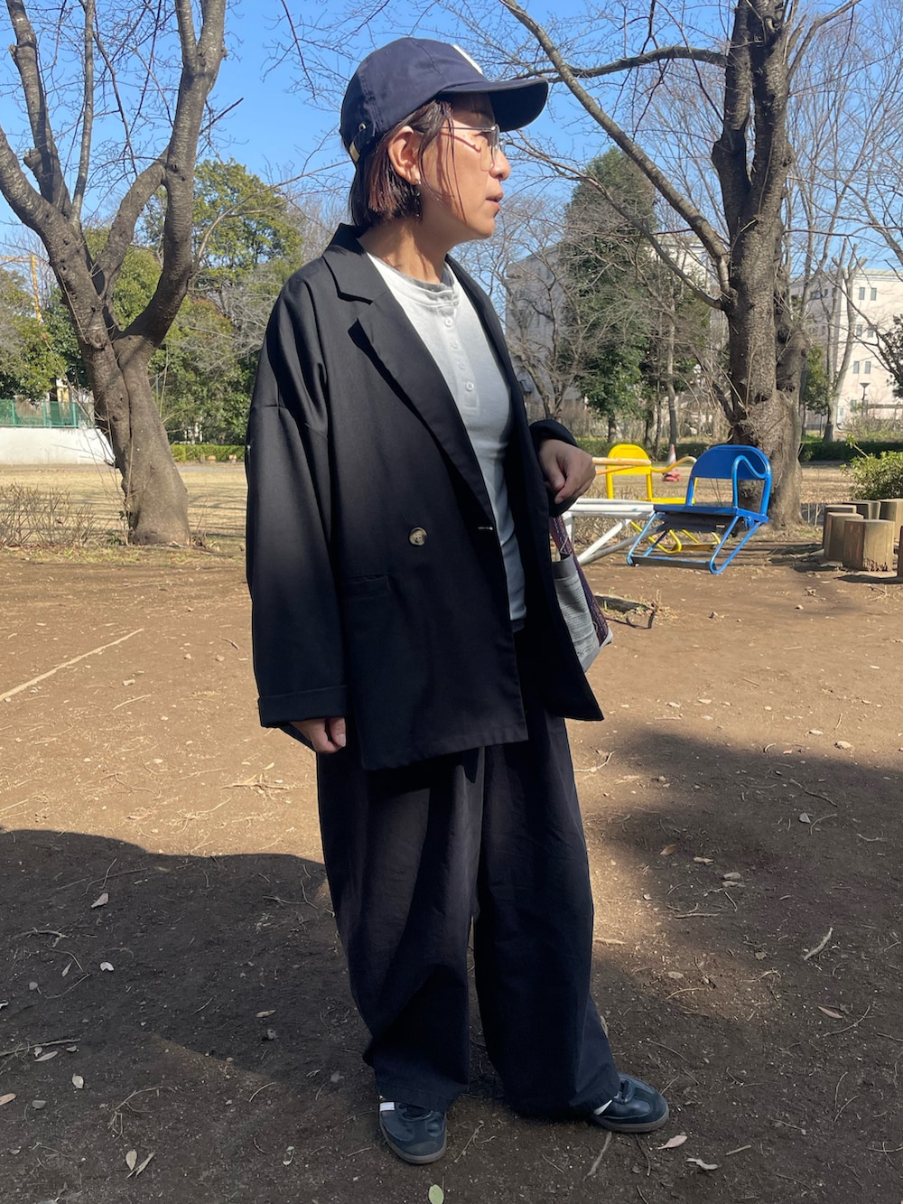 ホワイト系のTシャツ/カットソー、ブラック系のスラックス、ブラック系のスニーカーを着用したレディースの春コーディネートの3枚目の写真