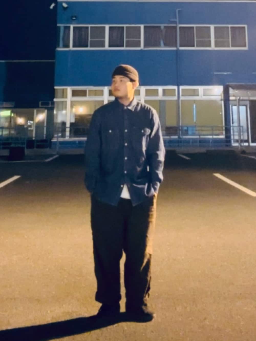 ブルー系のシャツ/ブラウス、ブラウン系のその他パンツ、ブラック系のスニーカーを着用したメンズの秋コーディネートの2枚目の写真