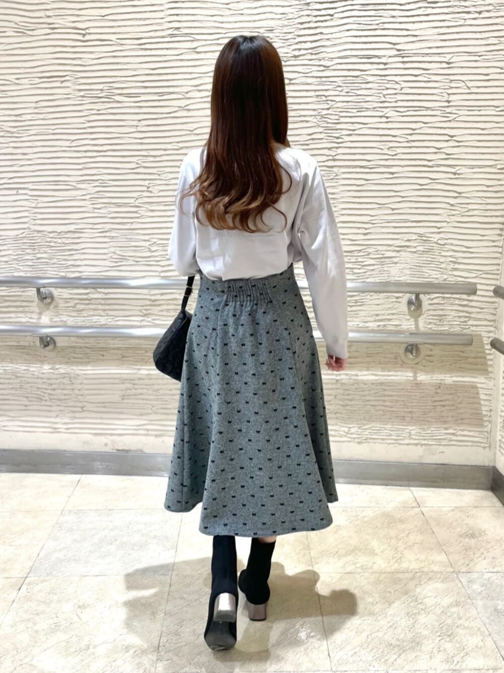 ブラック系のブーツ、ブラック系のショルダーバッグ、グレー系のニット/セーターを着用したレディースの冬コーディネートの3枚目の写真