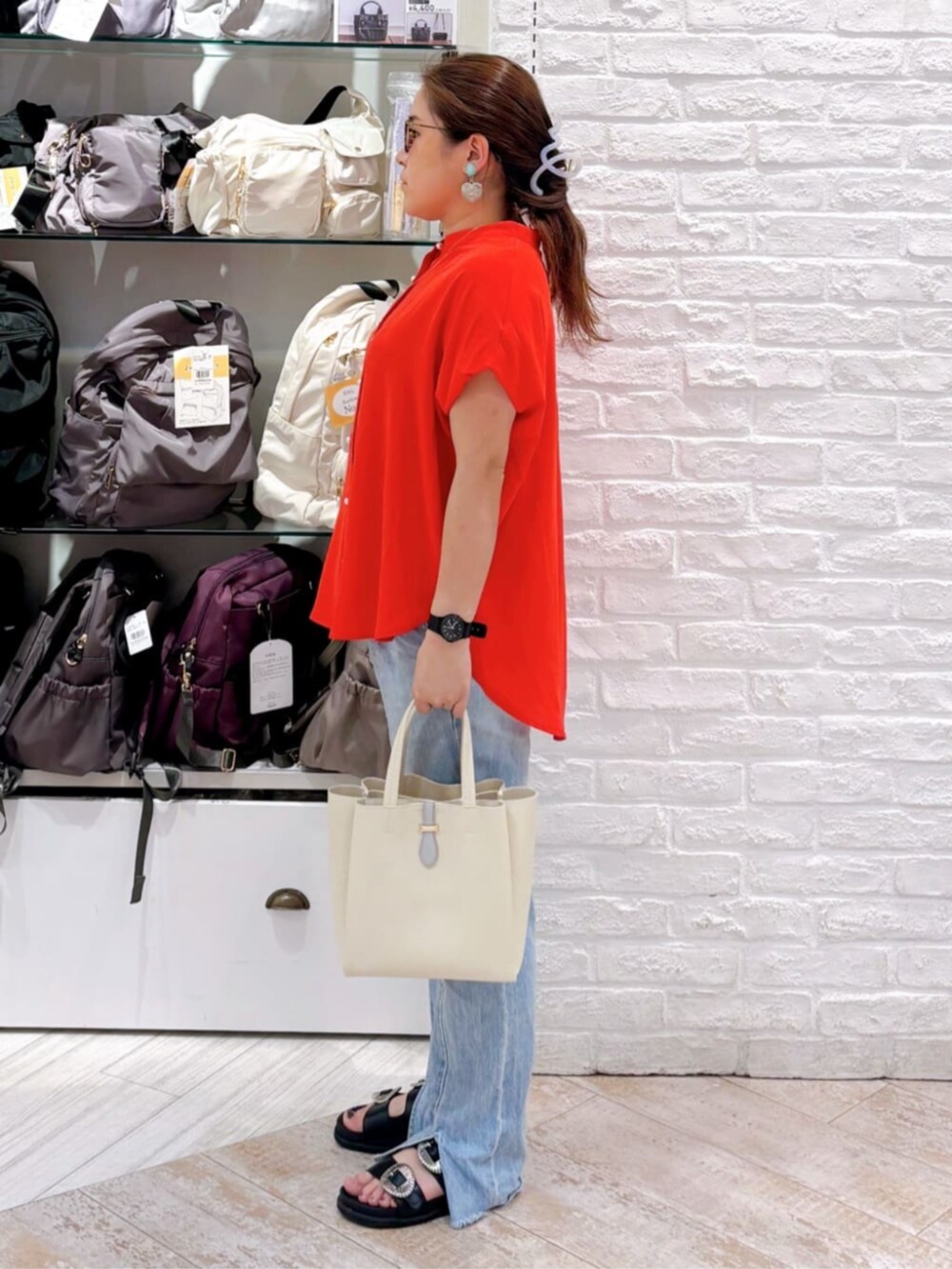 レッド系のシャツ/ブラウス、ホワイト系のハンドバッグ、シルバー系のネックレスを着用したレディースの夏コーディネートの2枚目の写真