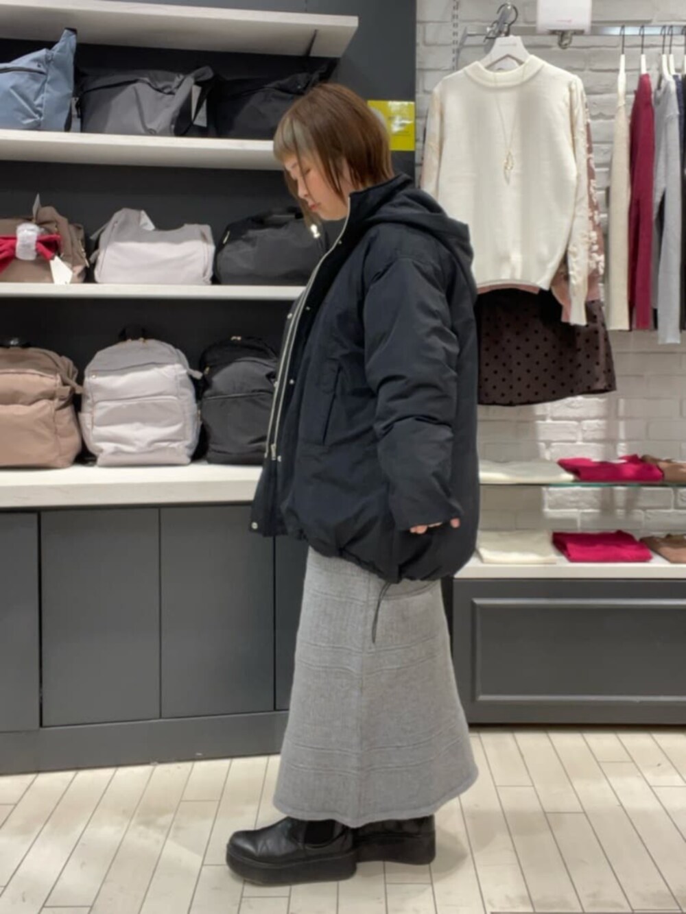 ホワイト系のTシャツ/カットソー、グレー系のスカート、ブラック系のその他アウターを着用したレディースの秋コーディネートの3枚目の写真